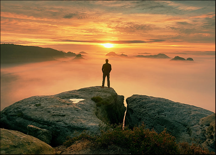 210549706 Man stands alone on the peak of rock, available in multiple sizes